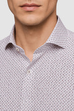 Load image into Gallery viewer, Close-up of a man wearing a light-colored button-down shirt with a small repeating geometric pattern in dark gray or black.